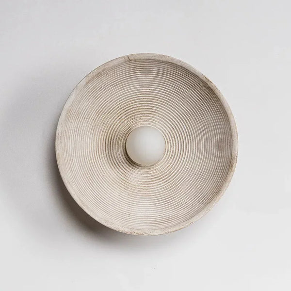 Applique murale ronde en résine texturée de style japonais, avec lignes concentriques et ampoule LED au centre. Idéale pour une atmosphère calme et minimaliste.