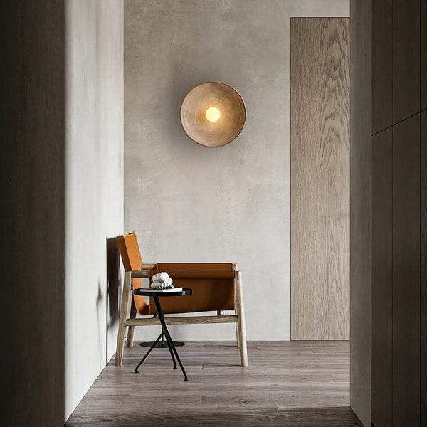Applique murale design en résine texturée, en forme de coupelle, diffusant une lumière chaude au centre. Parfaite pour un intérieur élégant et apaisant.
