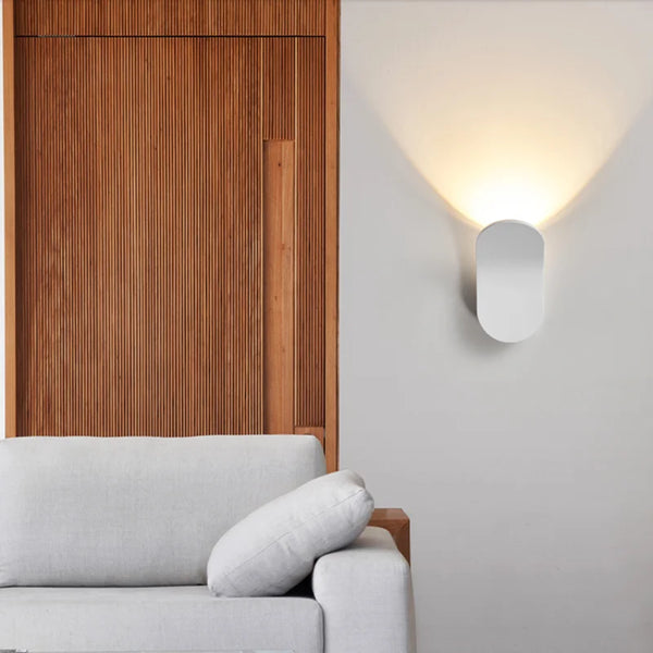Applique murale design minimaliste blanche avec éclairage indirect vers le haut. Parfaite pour une ambiance chaleureuse et moderne dans un salon ou une chambre.