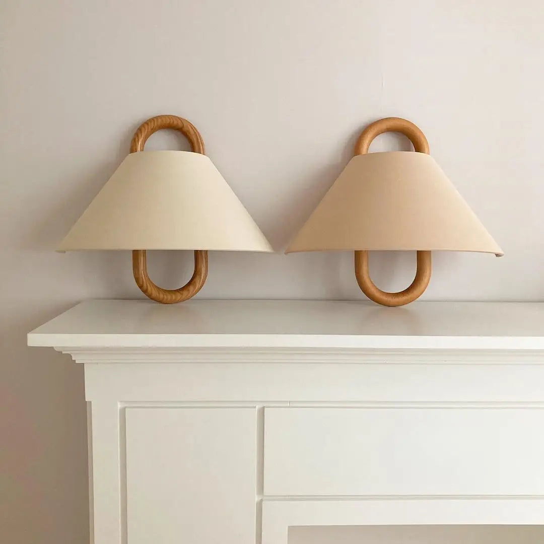 Applique murale au design vintage avec abat-jour en tissu naturel et poignées en bois arrondies. Un luminaire élégant pour une ambiance douce et authentique.
