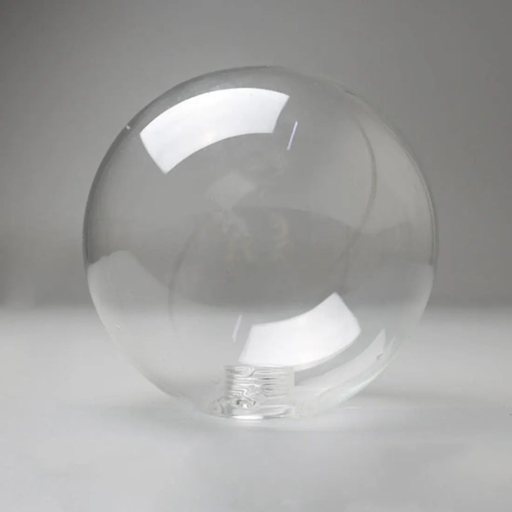 Globe en verre transparent pour plafonnier, au design épuré et arrondi. Surface lisse et finition cristalline pour une diffusion homogène de la lumière.