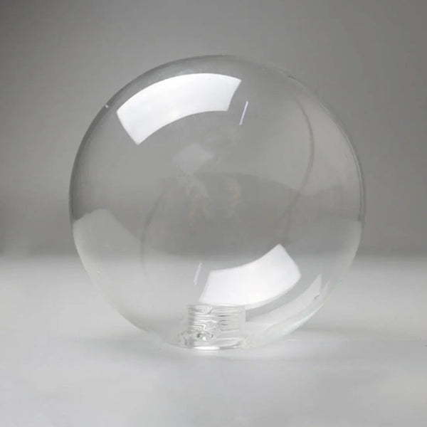 Globe en verre transparent pour plafonnier, au design épuré et arrondi. Surface lisse et finition cristalline pour une diffusion homogène de la lumière.
