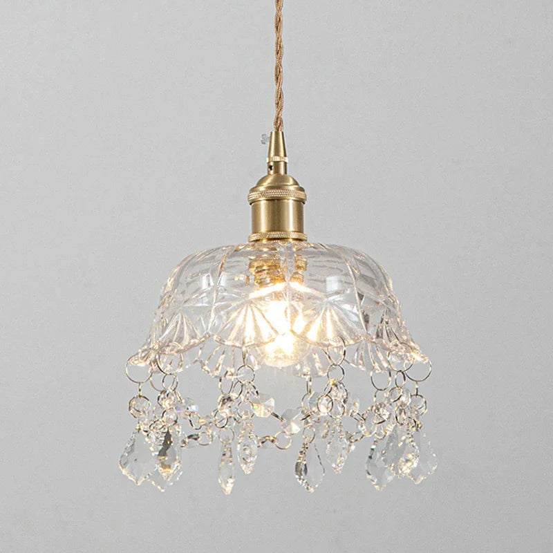 Lustre plafonnier vintage avec abat-jour en verre sculpté et pampilles en cristal suspendues. Fixation en laiton doré et câble torsadé pour une touche rétro élégante.