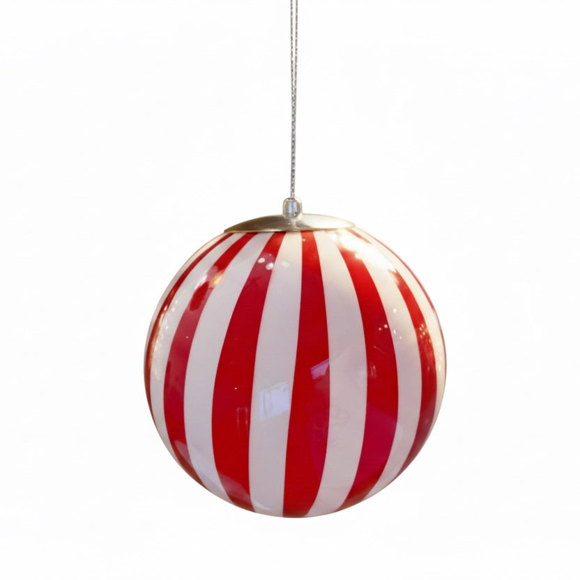 Plafonnier en verre soufflé en forme de boule rayée rouge et blanche, suspendu par un câble métallique. Son design évoque un bonbon rétro.