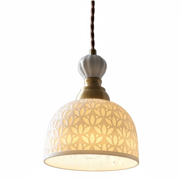 Suspension design en céramique ajourée diffusant une lumière douce et chaleureuse, idéale pour un intérieur raffiné et minimaliste.