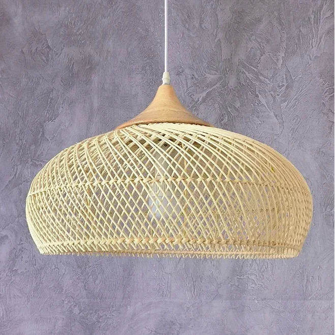 Plafonnier en rotin naturel de forme calebasse, avec un tressage ajouré en losanges et un sommet en bois lisse. Ce luminaire suspendu diffuse une lumière douce à travers sa structure, projetant des ombres décoratives sur les murs, idéal pour un intérieur au style naturel, bohème ou contemporain.