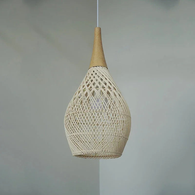 Suspension en rotin ajouré de forme goutte, suspendue par un câble discret, avec un sommet en bois lisse. Le tressage délicat crée une lumière douce et poétique, idéale pour une ambiance bohème ou naturelle.