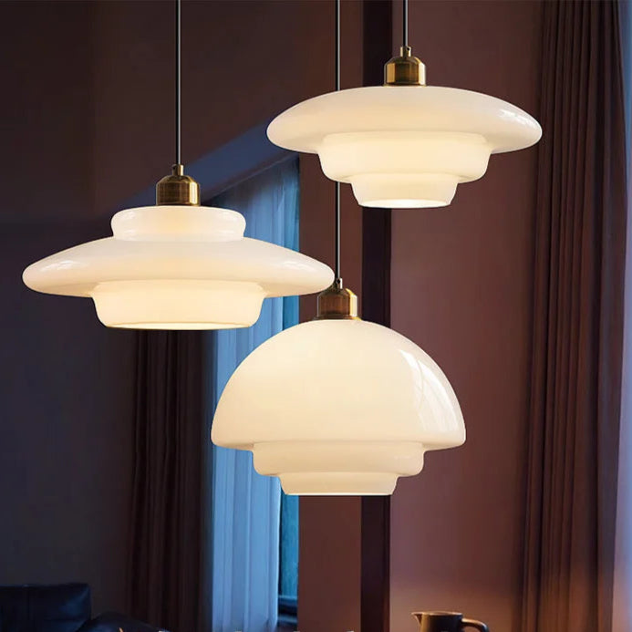 Suspension en verre opaline au design vintage avec structure en laiton doré. Formes sculpturales et lumière douce pour une ambiance chaleureuse et élégante.