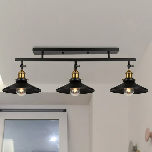 plafonnier 3 lampe de couleur noir avec une fixation en barre droite de couleur noir et des détails dorée sur un plafond de couleur blanche